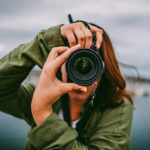 A young woman using a DSLR camera